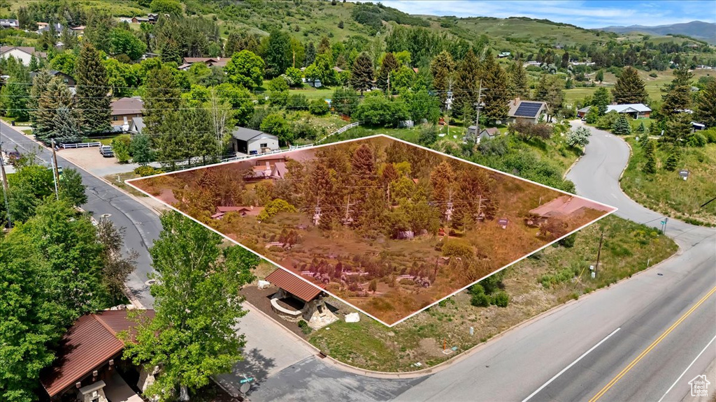Aerial overview of property's location featuring property boundaries highlighted and a mountain backdrop