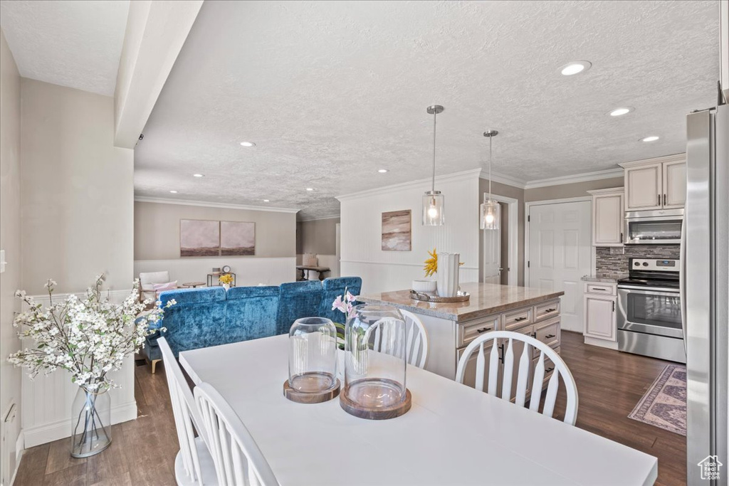 Dining space with recessed lighting, dark wood-type flooring, a textured ceiling, ornamental molding, and baseboards