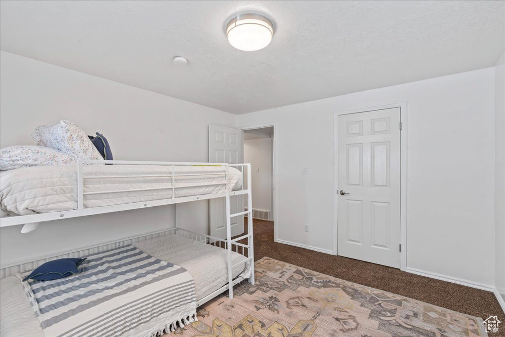 Bedroom featuring carpet and baseboards