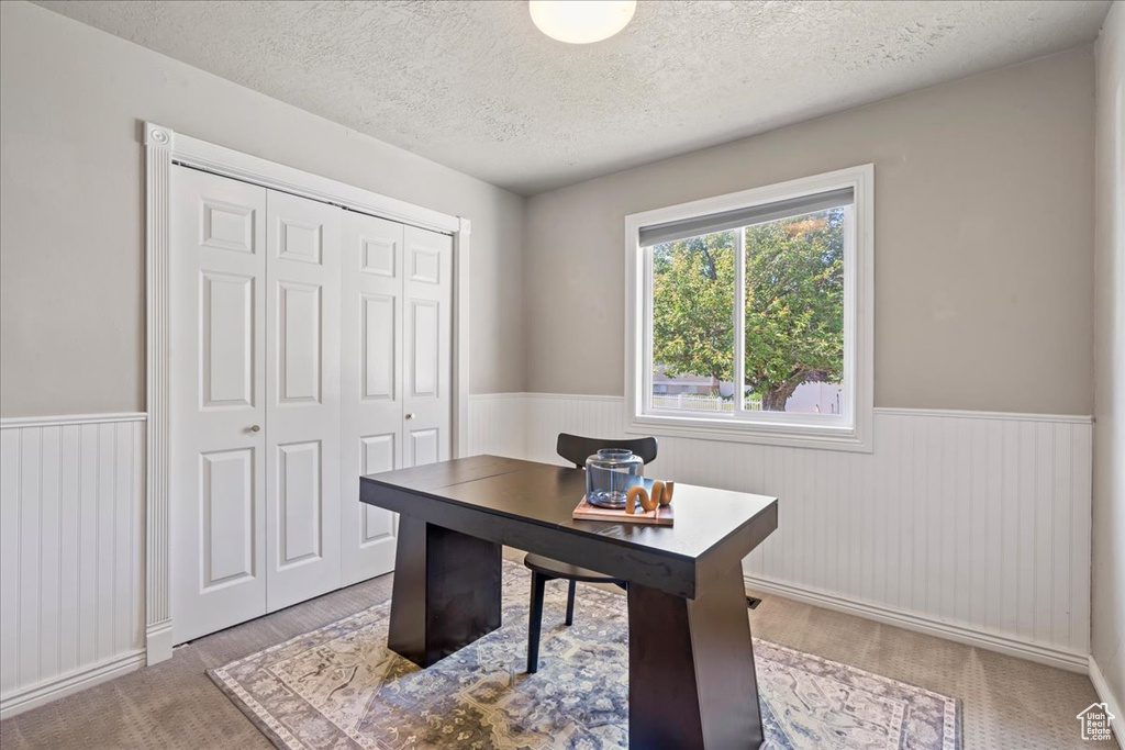 Office featuring wainscoting and a textured ceiling