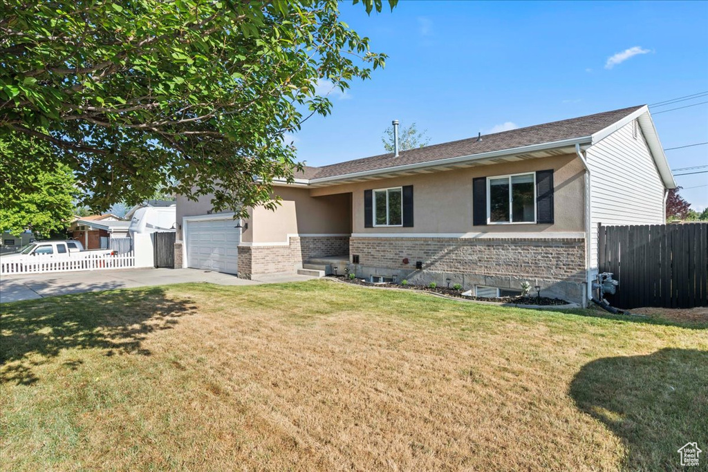 Ranch-style home with concrete driveway, brick siding, a garage, stucco siding, and roof with shingles