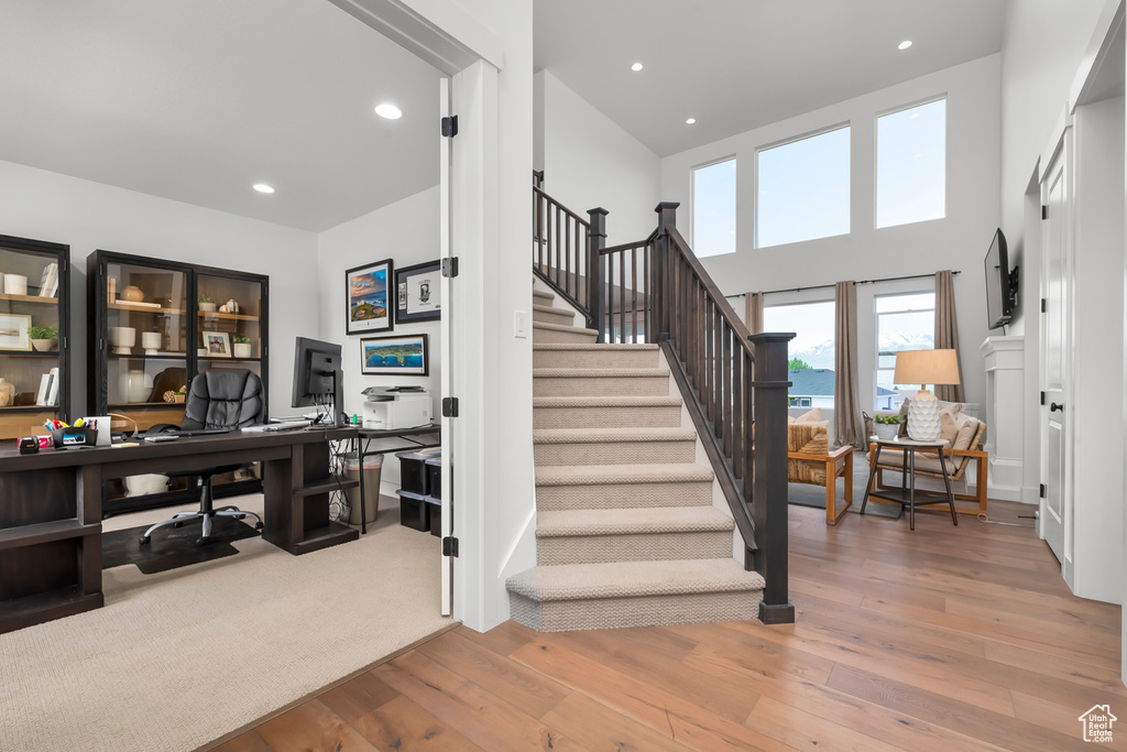 Staircase featuring hardwood / wood-style floors and recessed lighting