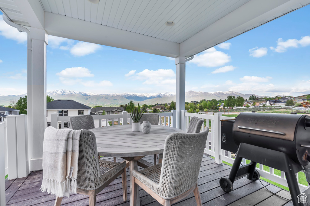 Wooden deck with a mountain view, grilling area, and outdoor dining space