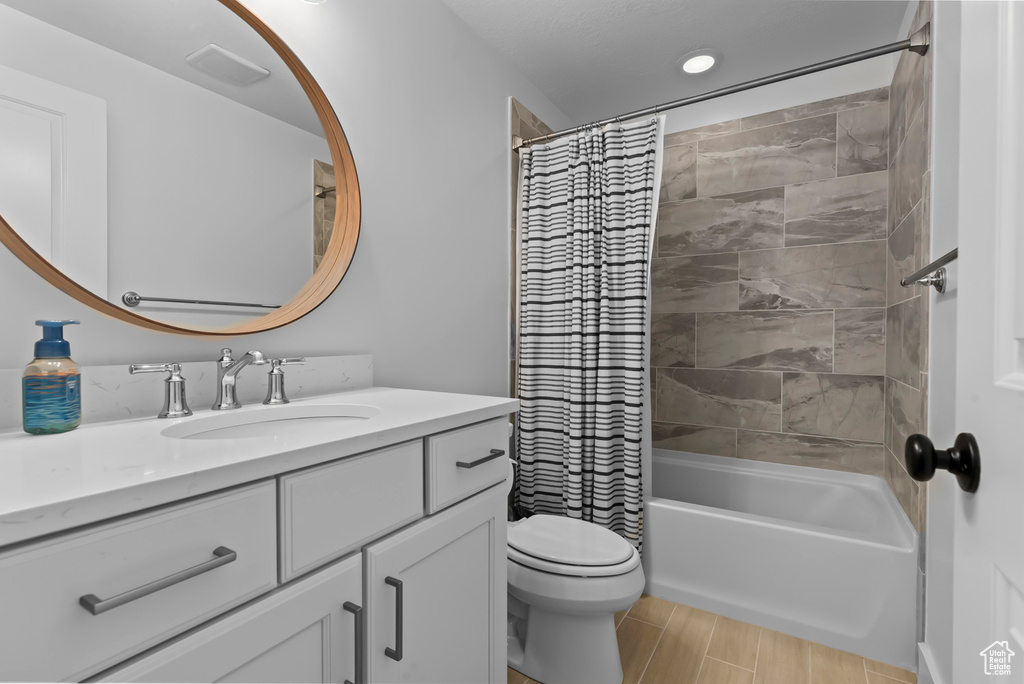 Bathroom with vanity, shower / bath combo, and wood finish floors
