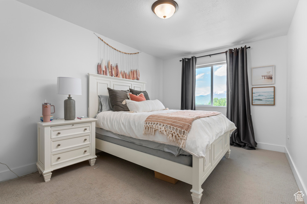 Bedroom featuring light carpet and baseboards