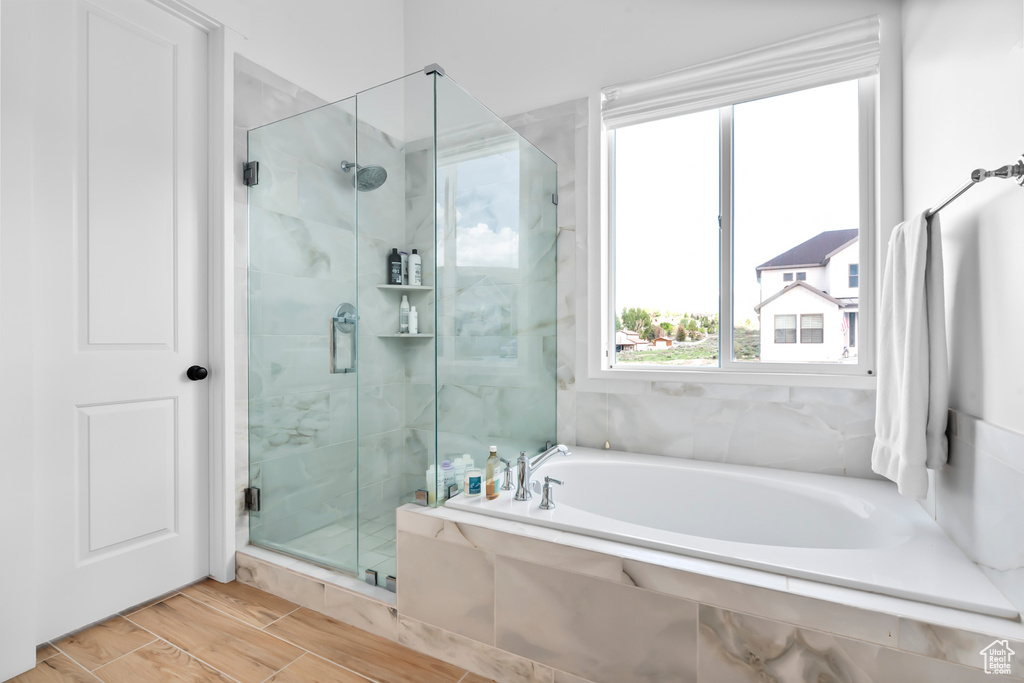 Full bath with a shower stall, a garden tub, and wood tiled floors