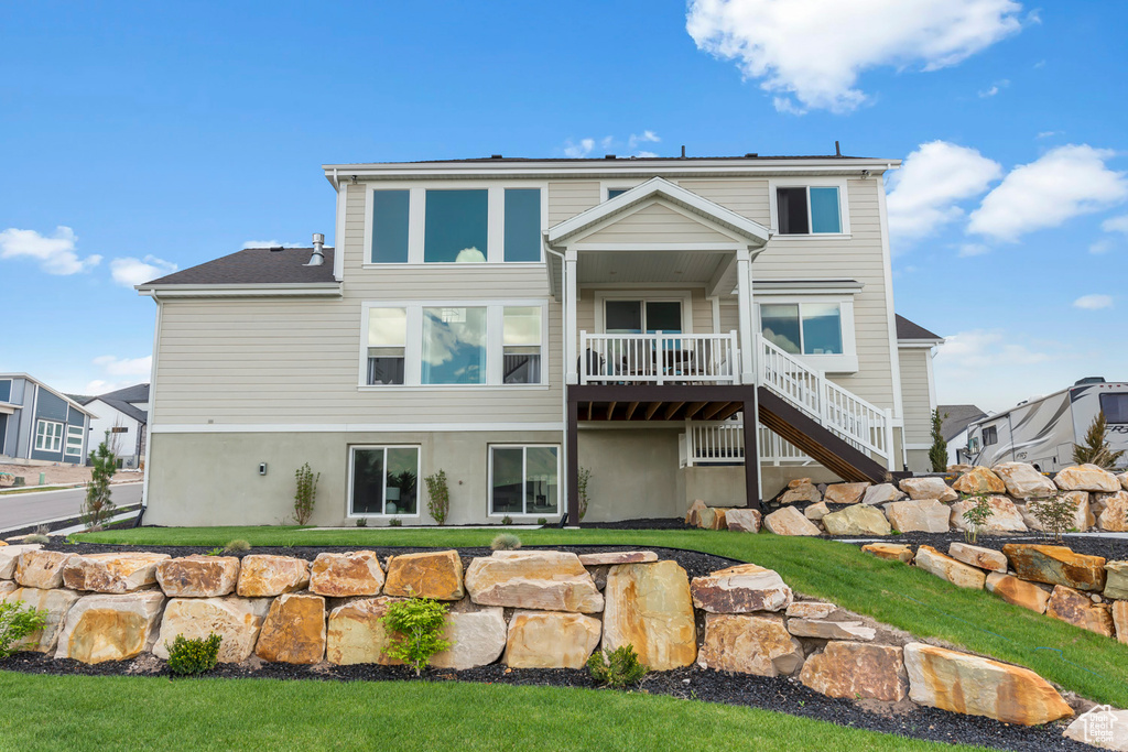 Rear view of house featuring stairway, a yard, and a deck
