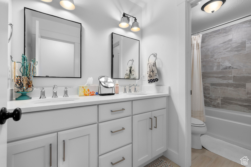 Full bathroom with double vanity and shower / tub combo