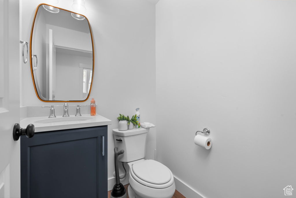 Half bathroom featuring vanity and toilet