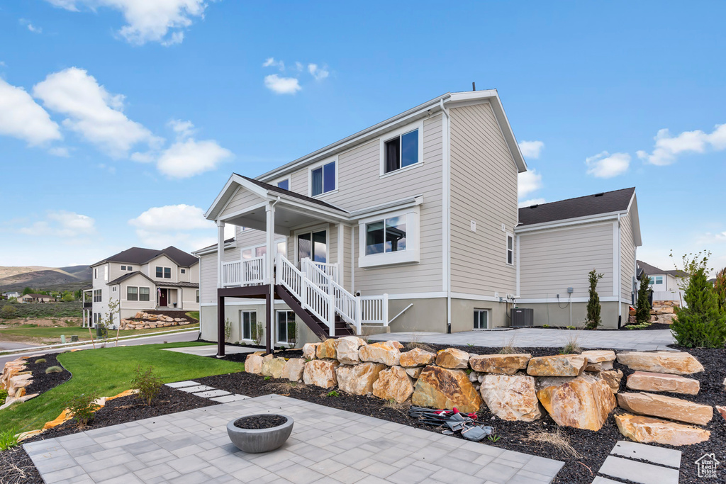 Back of house featuring a patio area, stairs, an outdoor fire pit, and a yard