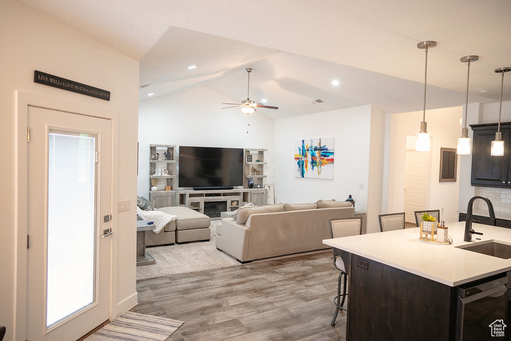 Living area featuring vaulted ceiling, wood finished floors, and ceiling fan