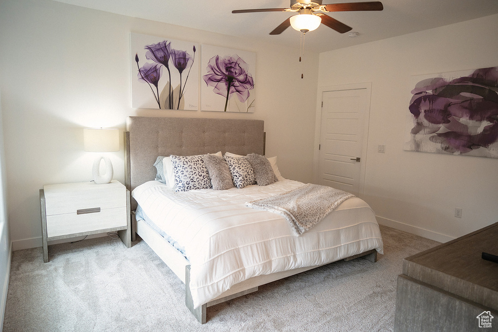 Carpeted bedroom featuring baseboards and a ceiling fan