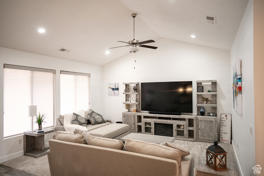 Living area with ceiling fan, lofted ceiling, recessed lighting, light carpet, and a fireplace