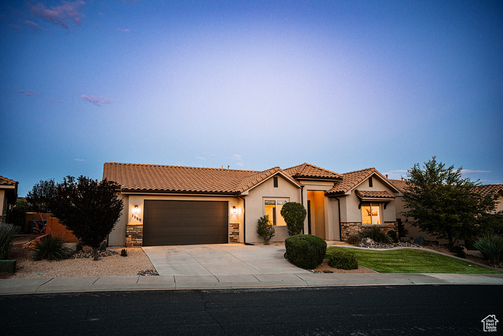 Mediterranean / spanish home with stone siding, stucco siding, and a tiled roof