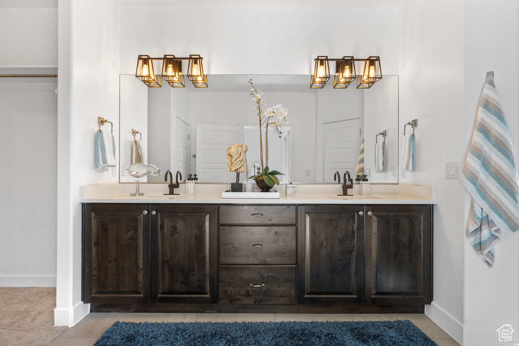 Bathroom featuring double vanity and baseboards