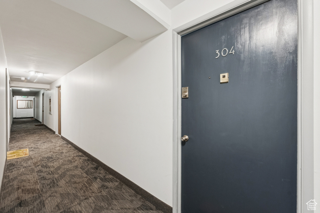 Hallway featuring carpet and baseboards