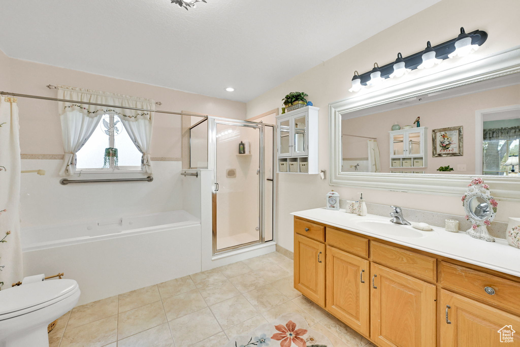 Full bath with vanity, a shower stall, a garden tub, and plenty of natural light
