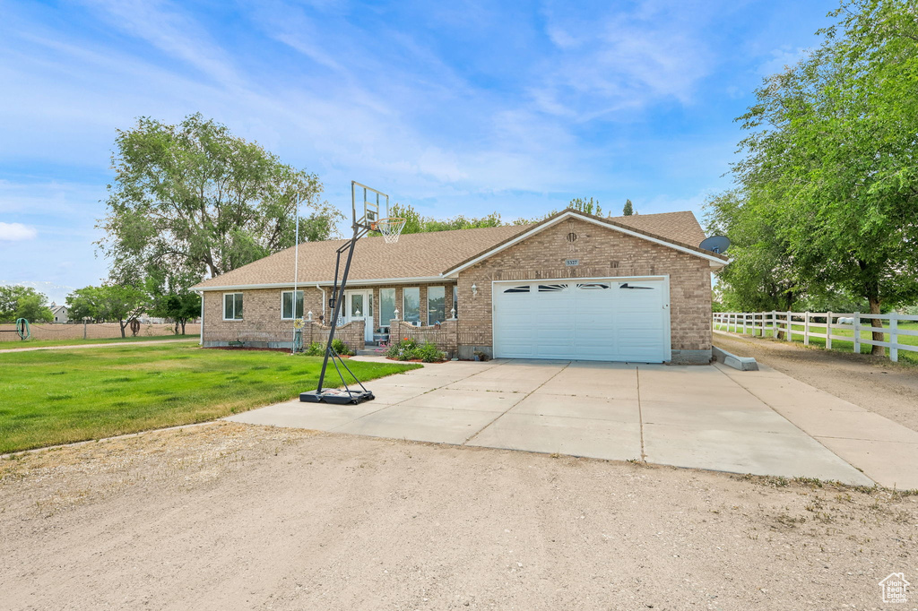 Ranch-style house featuring brick siding, a garage, and driveway