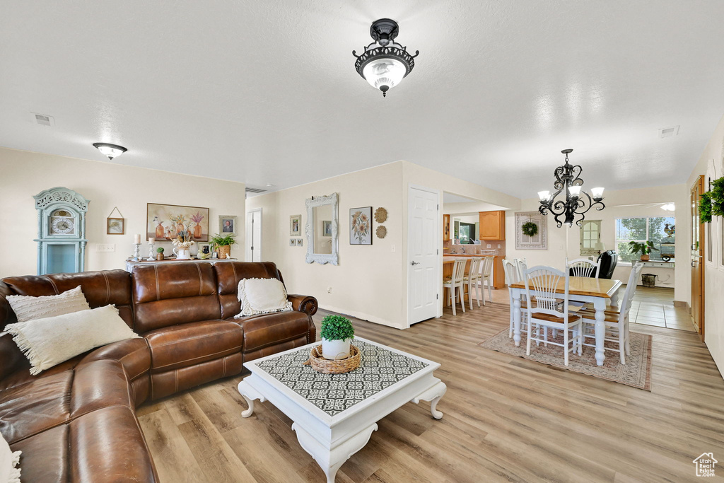 Living room with a chandelier and light wood-style floors