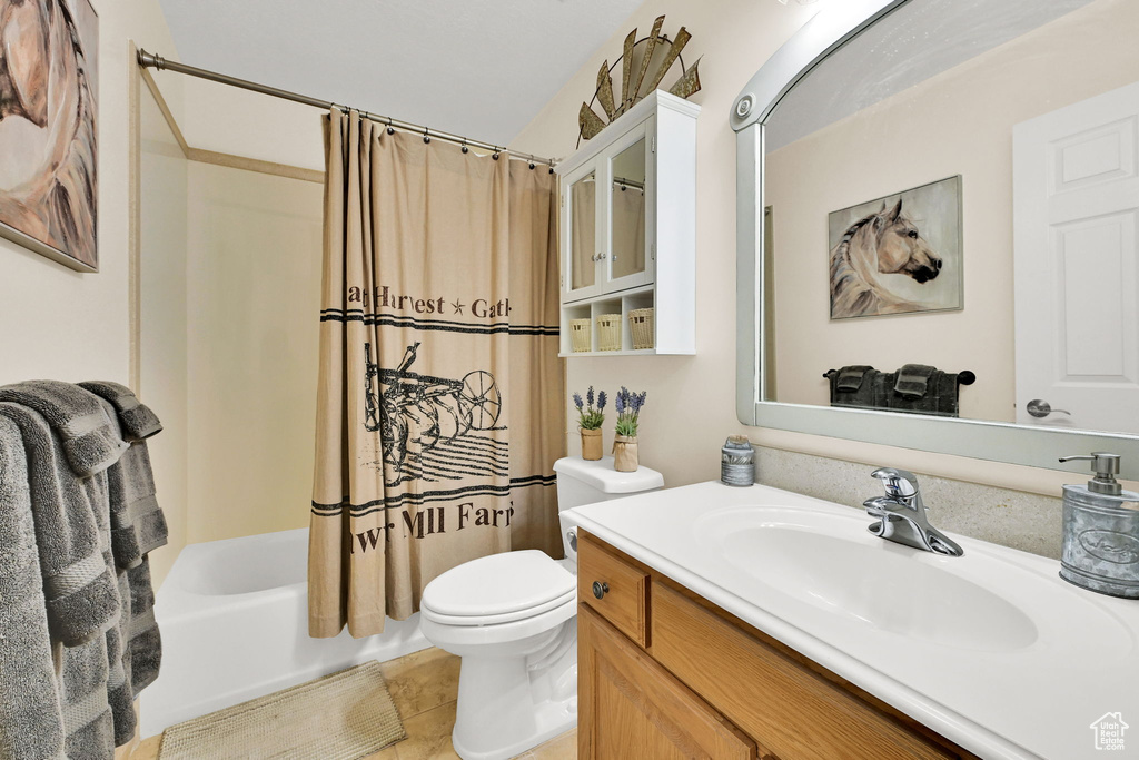 Bathroom featuring vanity, shower / bath combo with shower curtain, and tile patterned floors