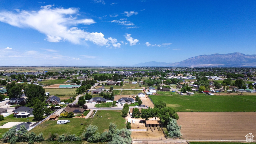 Aerial view of property and surrounding area featuring mountains and nearby suburban area