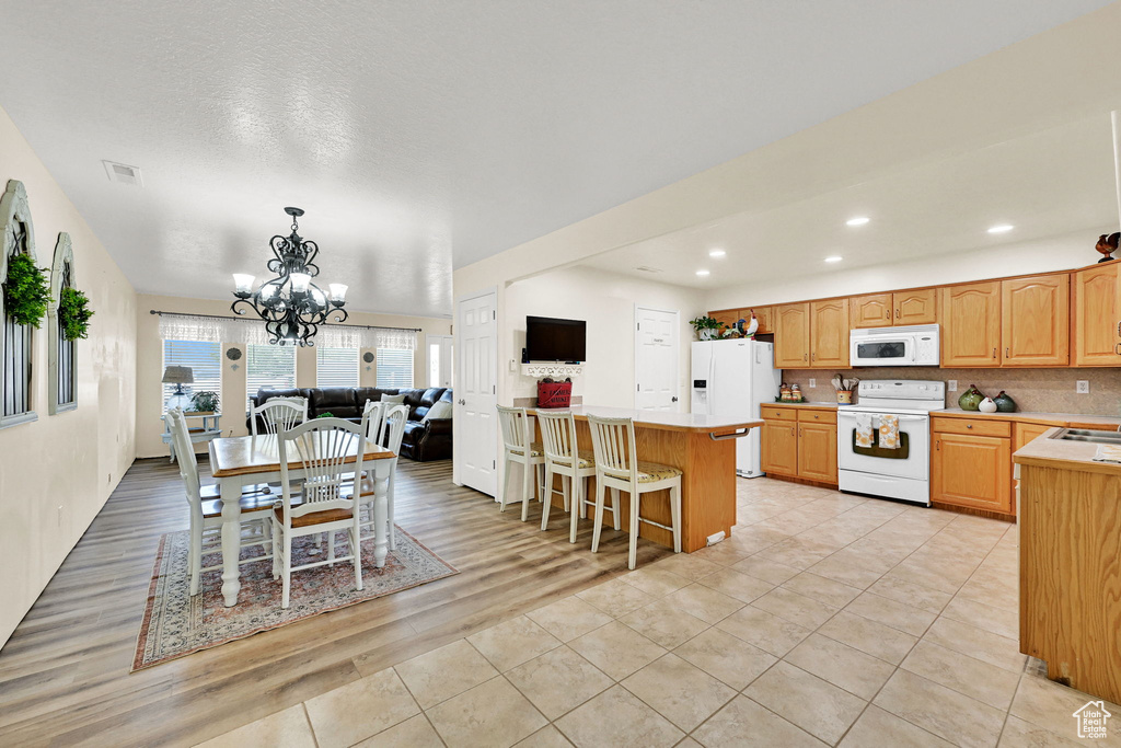 Dining space with a chandelier, recessed lighting, and light tile patterned floors
