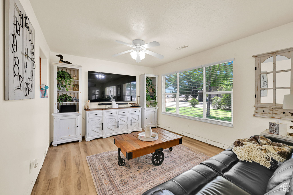 Living room with light wood-style flooring and a ceiling fan
