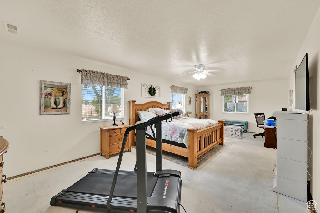 Bedroom featuring multiple windows and ceiling fan