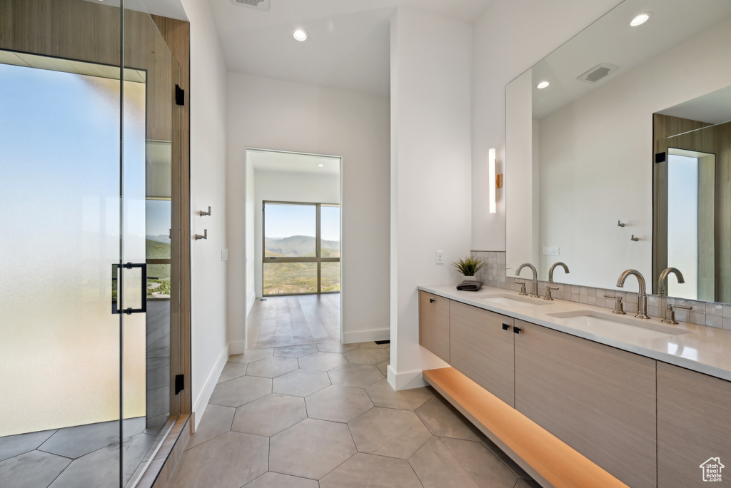Bathroom with double vanity, recessed lighting, a shower stall, baseboards, and tile patterned floors