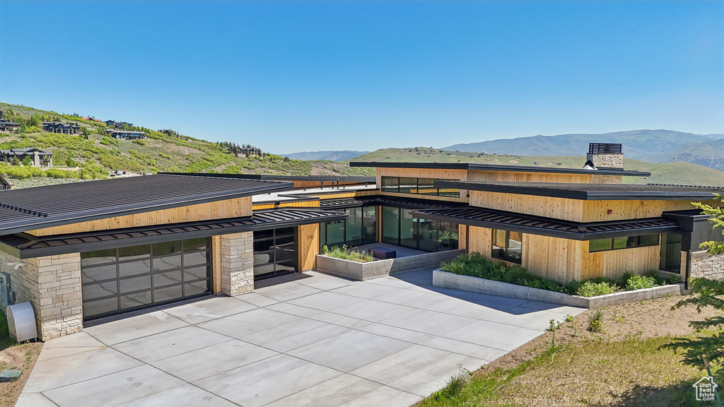 View of front of property featuring a standing seam roof, a mountain view, and metal roof
