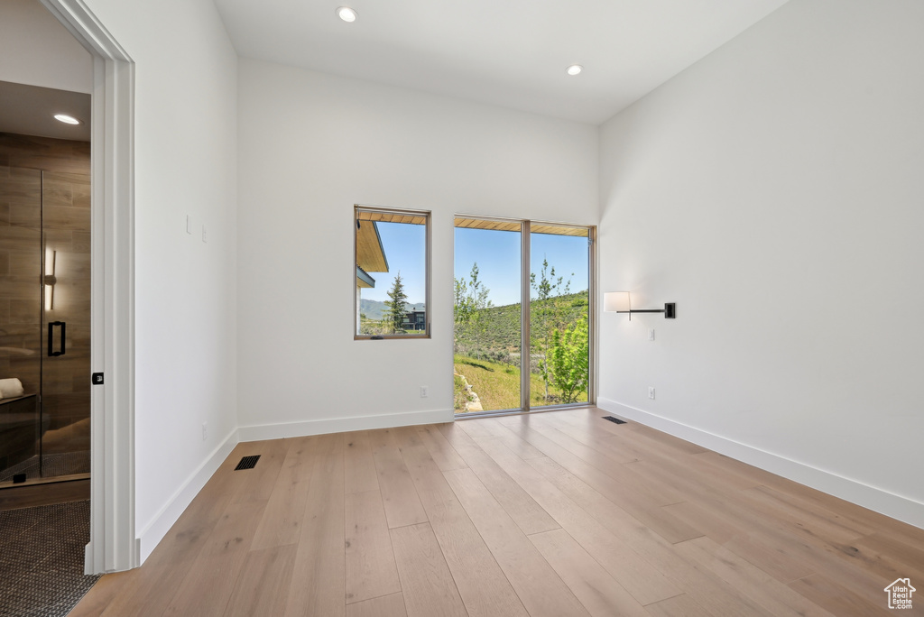 Unfurnished room featuring baseboards, light wood-type flooring, and recessed lighting