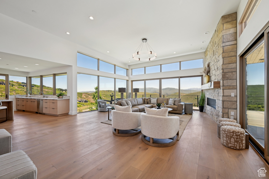 Living area with a chandelier, a fireplace, light wood-style floors, recessed lighting, and a mountain view