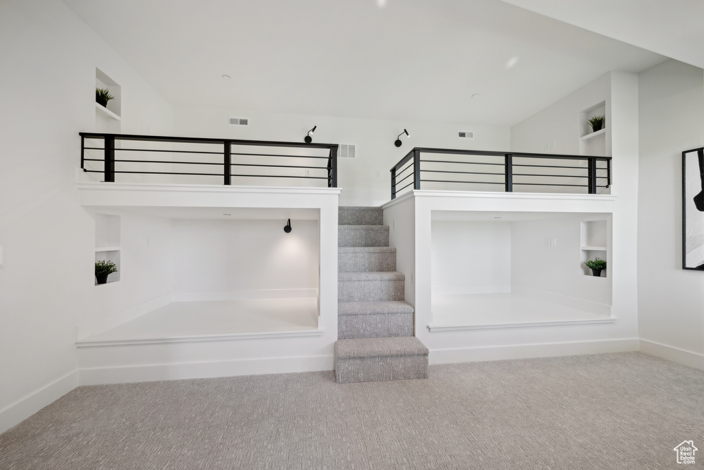 Staircase with carpet flooring, built in shelves, and baseboards