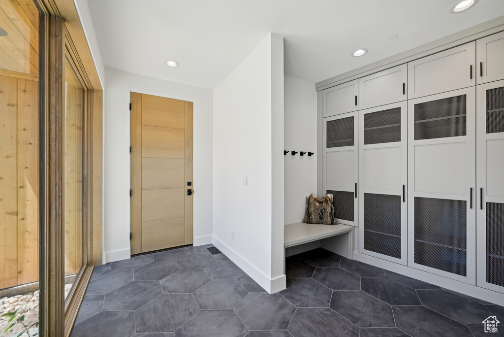 Mudroom featuring recessed lighting, baseboards, and dark tile patterned floors