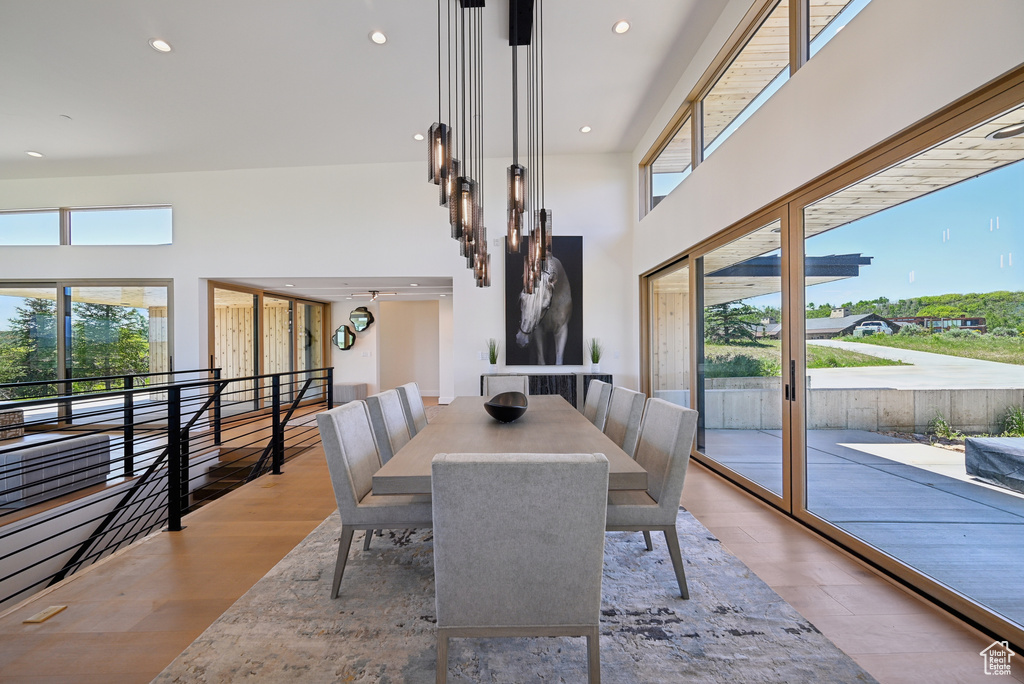 Dining area featuring a high ceiling, recessed lighting, and wood finished floors