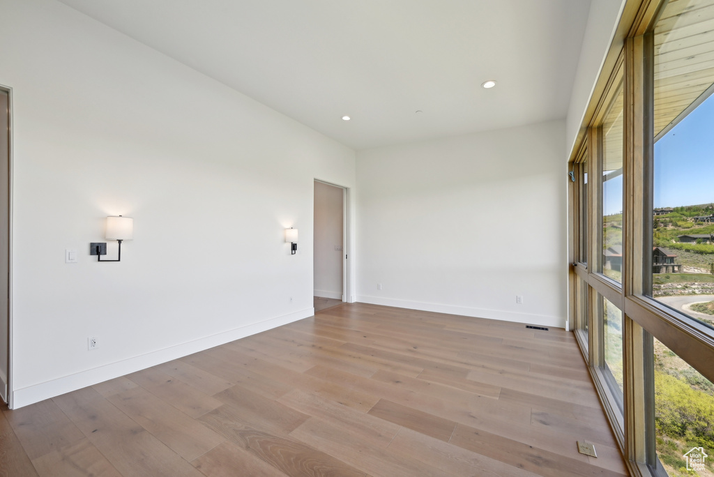 Spare room featuring light wood-type flooring, baseboards, and recessed lighting