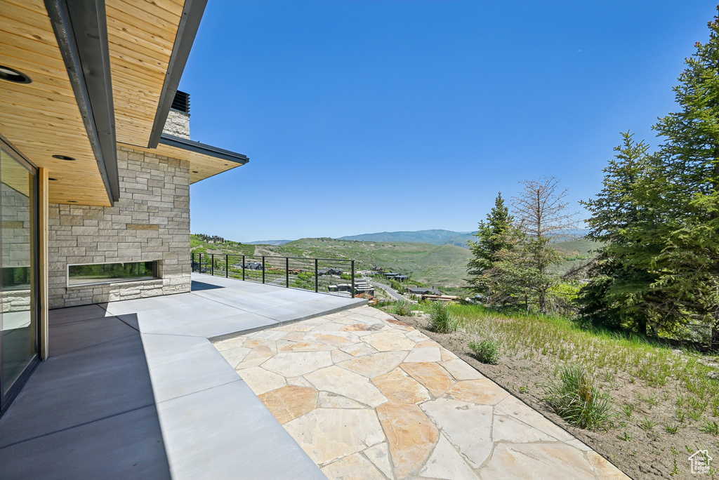 View of patio / terrace featuring an outdoor stone fireplace and a mountain view