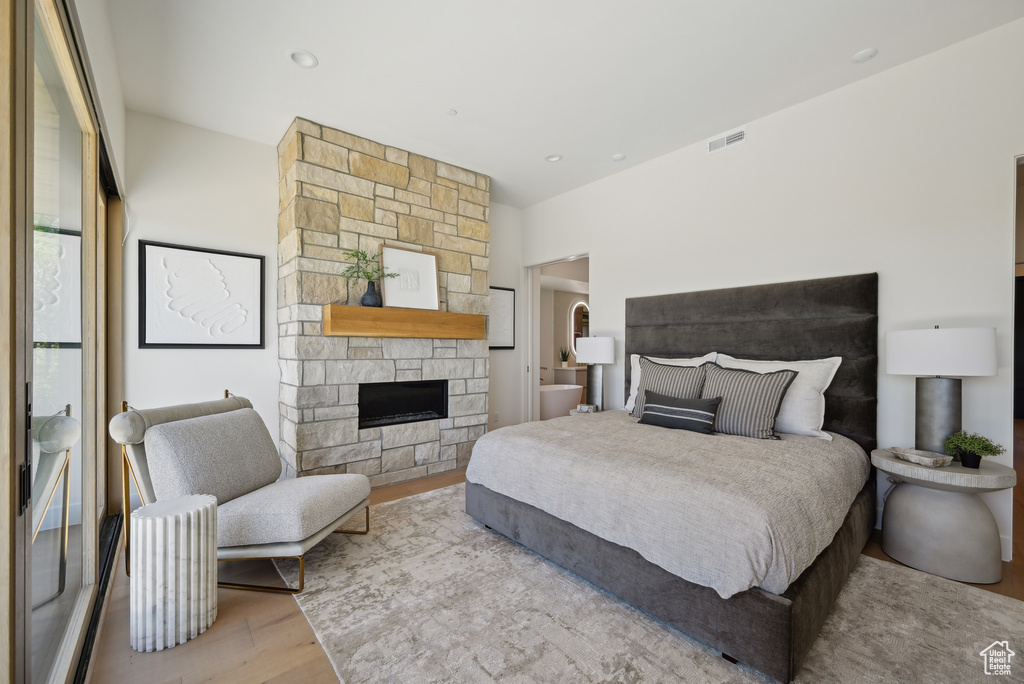 Bedroom with wood finished floors and a fireplace