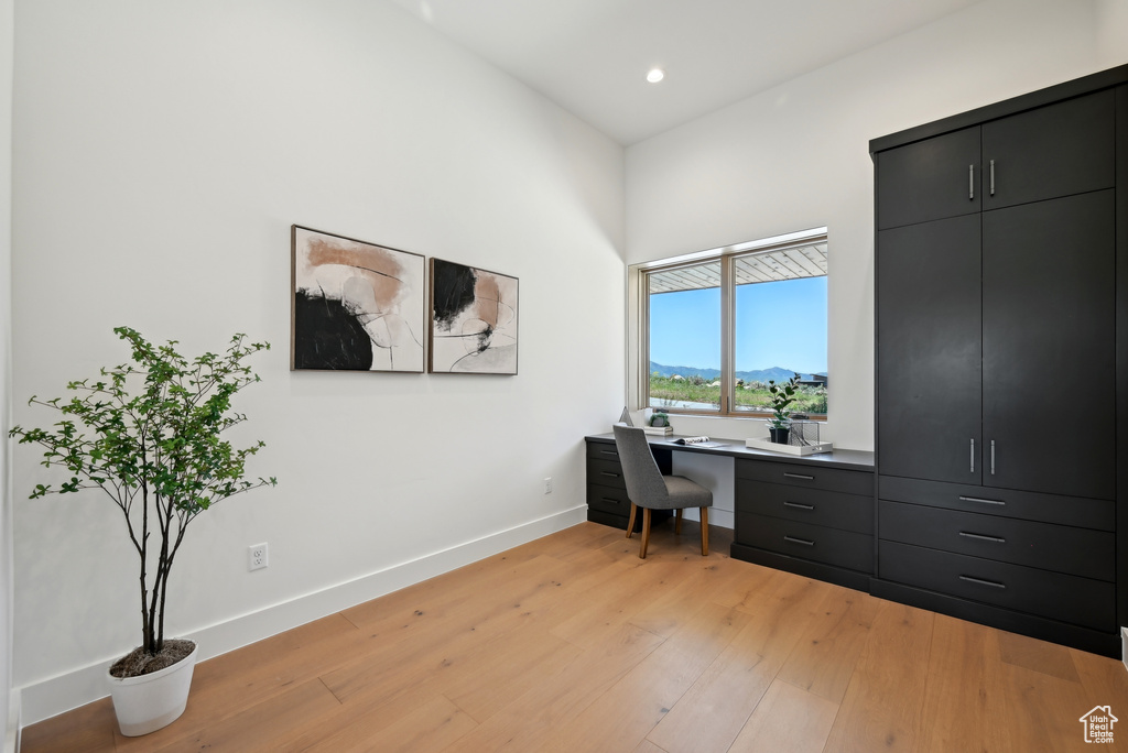 Office space with light wood-type flooring, baseboards, recessed lighting, built in study area, and a mountain view