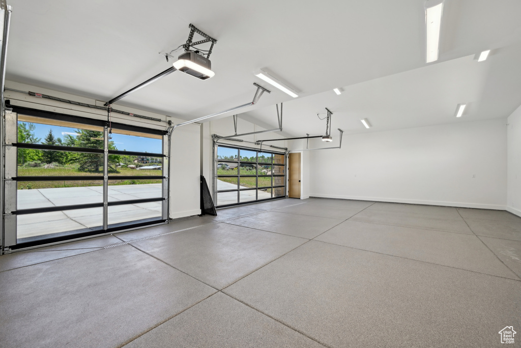 Garage featuring baseboards and a garage door opener
