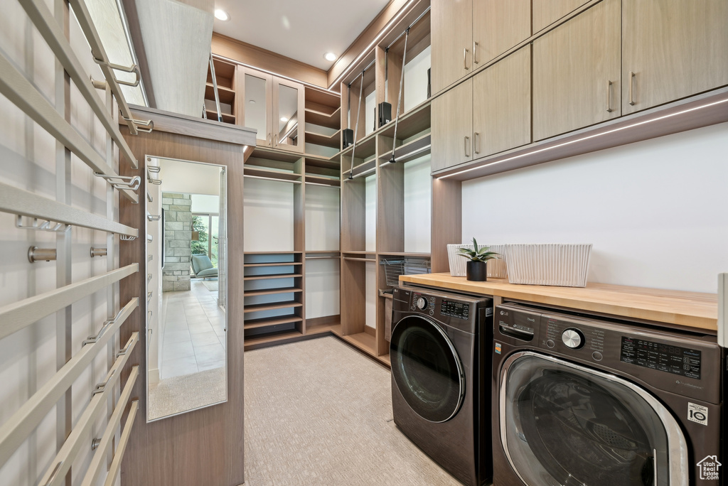 Laundry room with separate washer and dryer, cabinet space, light colored carpet, and recessed lighting