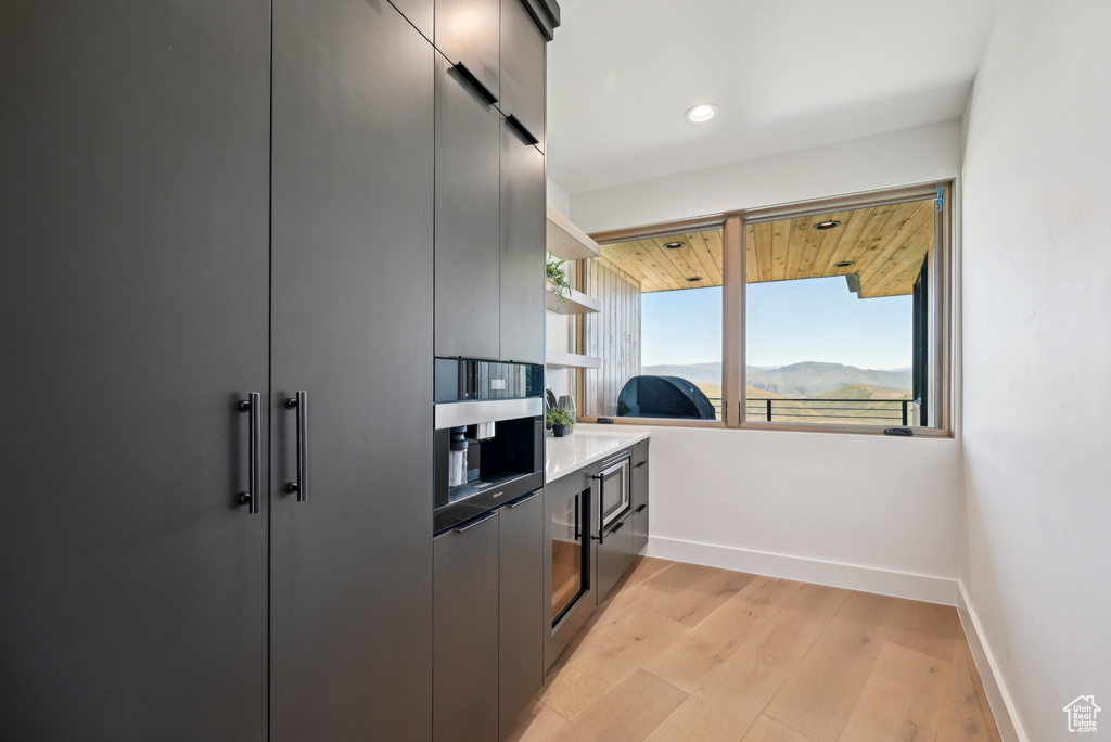 Kitchen with modern cabinets, baseboards, light wood-style floors, recessed lighting, and open shelves