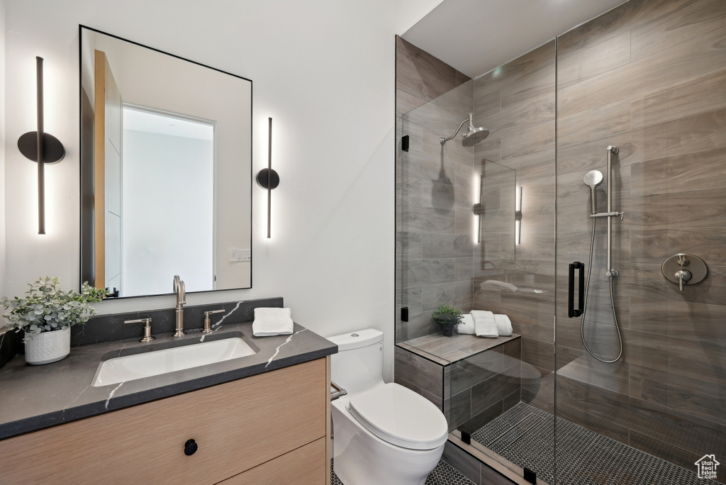 Full bath featuring toilet, vanity, and a stall shower