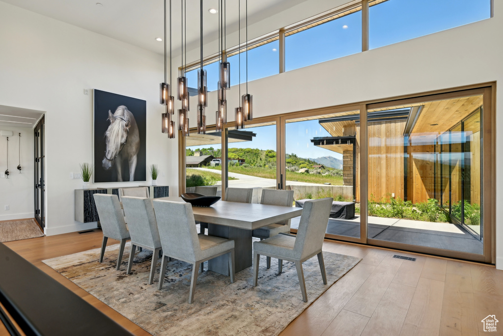Dining space featuring a towering ceiling, wood finished floors, recessed lighting, and baseboards