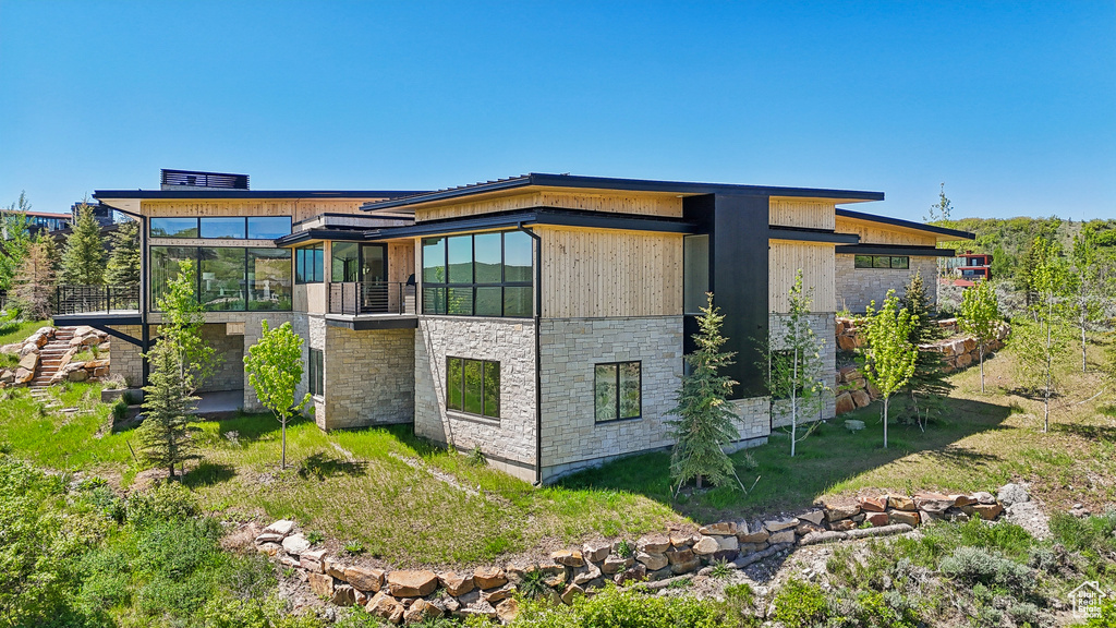 View of home\'s exterior with stone siding and a sunroom