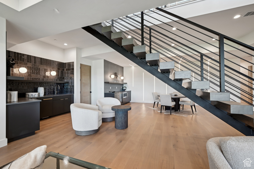 Living area featuring light wood finished floors, stairway, and recessed lighting