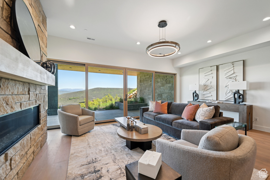 Living area featuring wood finished floors, recessed lighting, a stone fireplace, and a mountain view