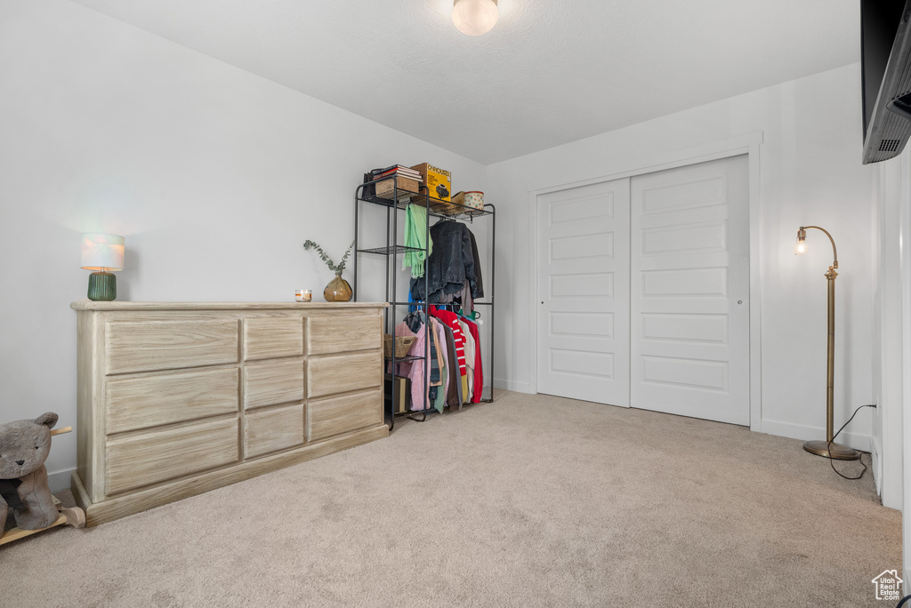 Carpeted bedroom featuring a closet and baseboards