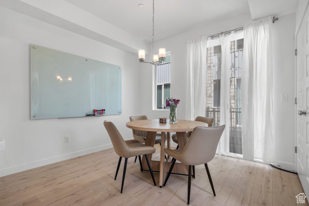 Dining room featuring plenty of natural light, a chandelier, and wood finished floors