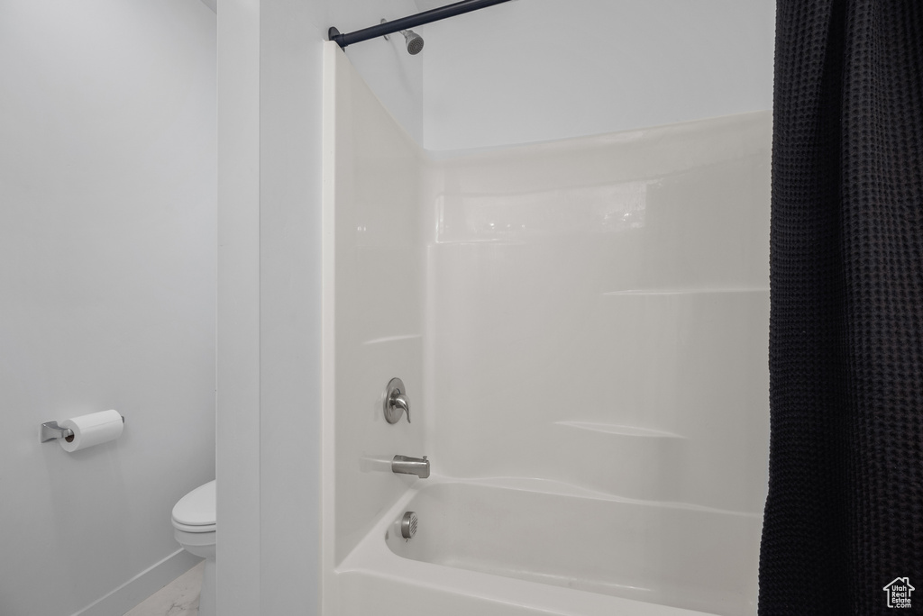 Bathroom featuring baseboards and shower / tub combo